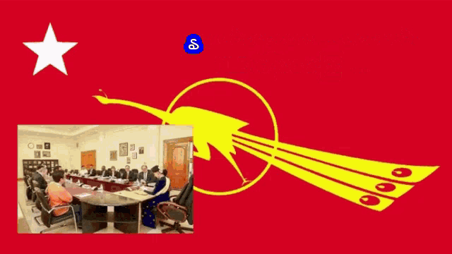 a group of people sit around a table in front of a red flag with foreign writing on it