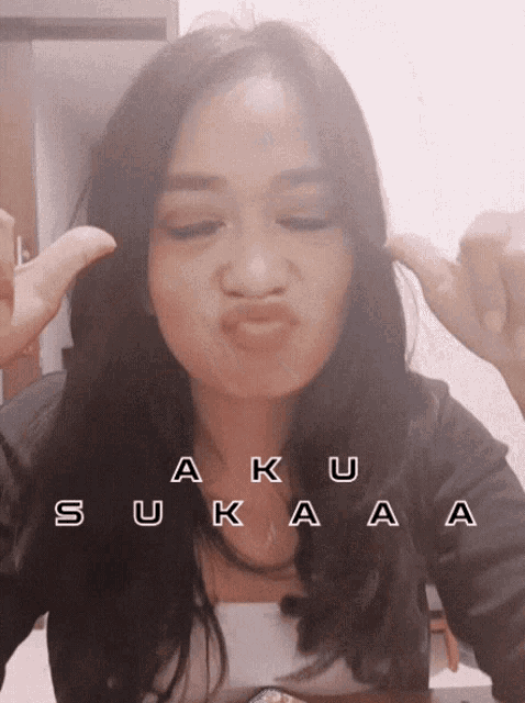 a woman making a funny face with the words aku suka aa written above her
