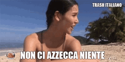 a woman sitting on a beach with the words trash italiano written on the bottom
