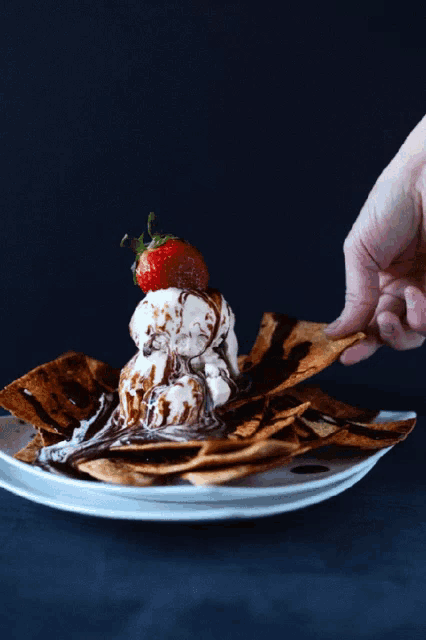 a strawberry is on top of a stack of ice cream