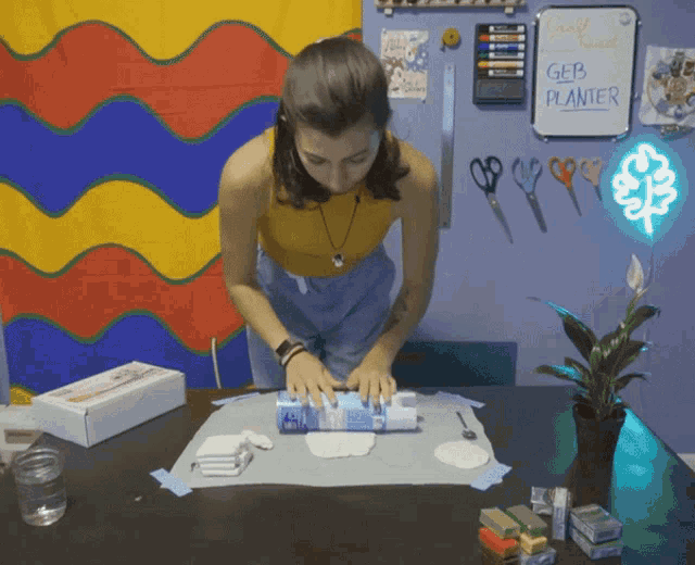 a woman sitting at a table with a white board that says geb planter