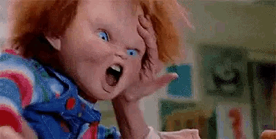 a close up of a child 's play doll with its mouth open and a hand on its head .