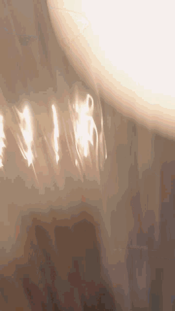 a close up of a light bulb with a reflection of the sun
