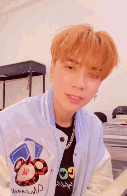 a young man wearing a jacket with a mickey mouse on it