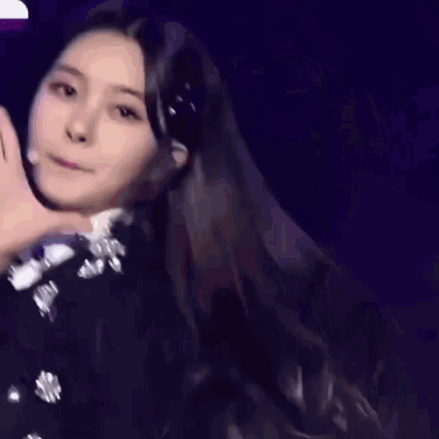 a close up of a woman 's face while she waves her hand .