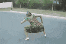 a woman in a green dress is standing on the side of a road