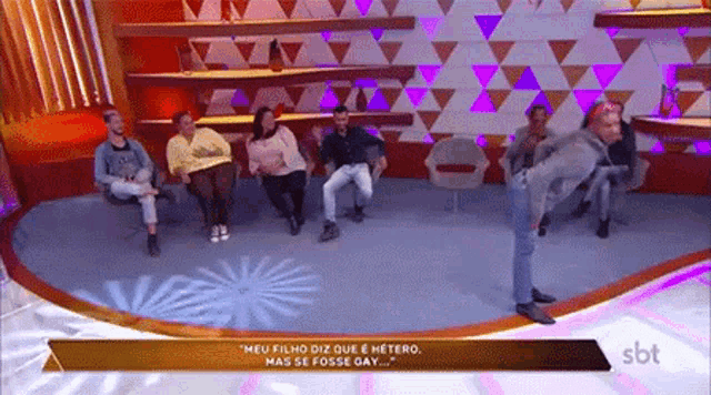 a group of people are sitting in a room with a sbt logo on the bottom