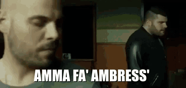 two men are standing next to each other in a dark room and one of them is saying `` amma fa ' ambress '' .