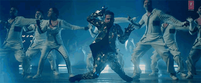a group of people are dancing in a dark room with a t on the bottom
