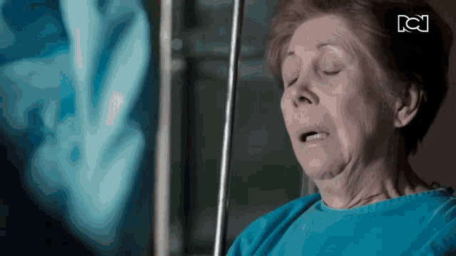 an older woman in a hospital gown with the letter c on the bottom left