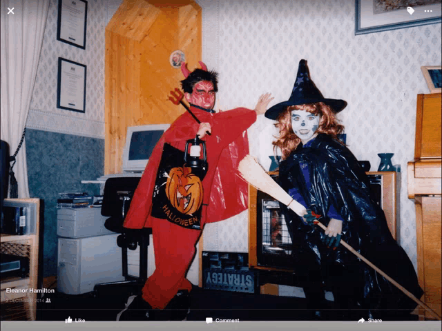 a man in a devil costume and a woman in a witch costume are posing for a photo