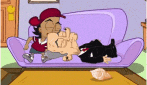 a man in a suit and tie is laying on a couch with another man in a red hat