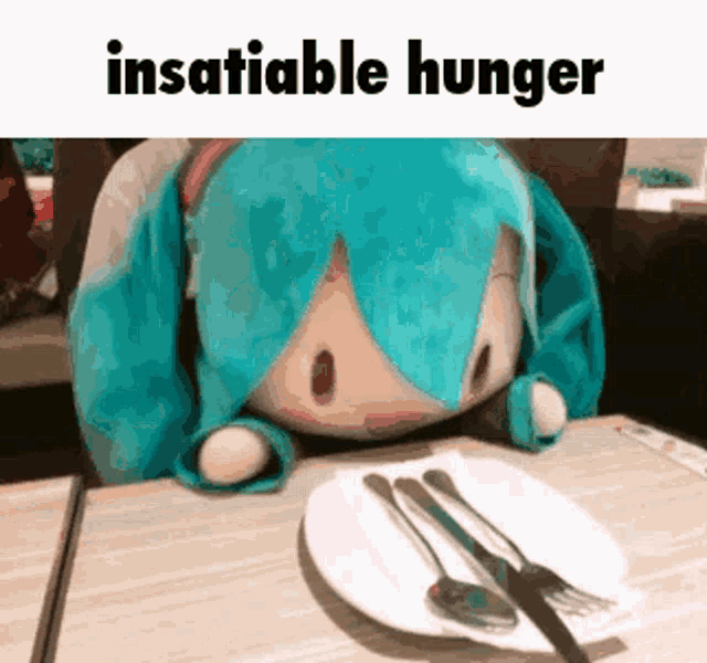 a stuffed animal with blue hair is sitting at a table with a plate of food and silverware .
