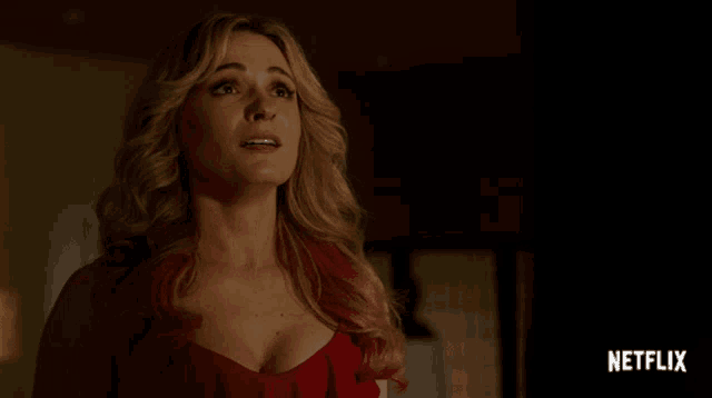 a woman in a red dress with a netflix logo in the background