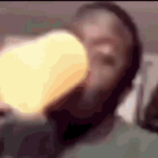 a blurry photo of a man drinking from a bottle