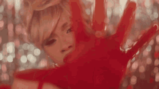 a woman covering her face with a red hand