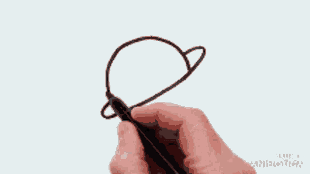 a person is drawing a hat with a black marker on a piece of paper ..