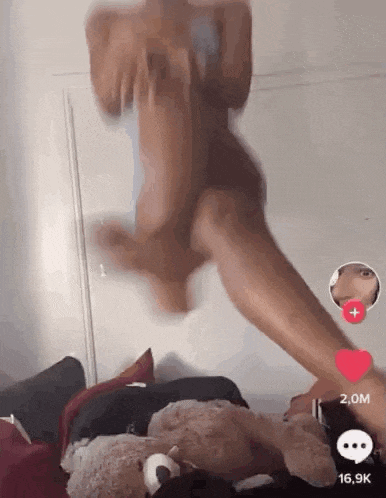a woman is jumping in the air with a teddy bear in her hand .