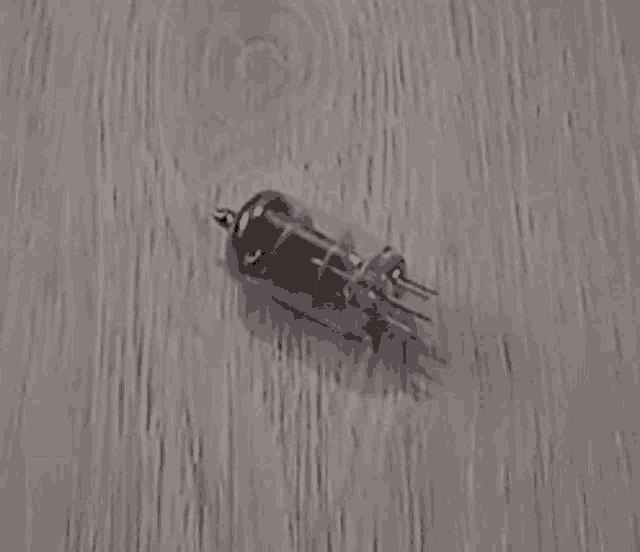 a black balloon is sitting on top of a wooden surface .