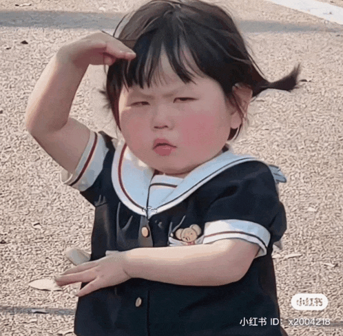 a little girl wearing a sailor 's uniform with a teddy bear on it