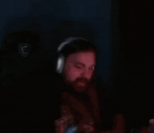 a man with a beard wearing headphones in the dark