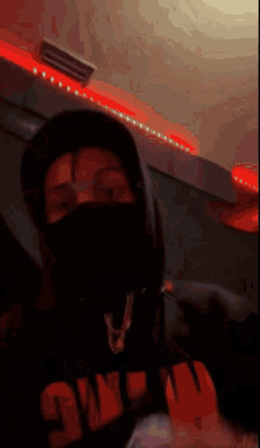 a person wearing a mask and a hoodie that says ow