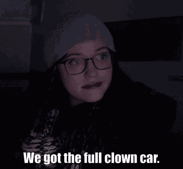 a woman with glasses and a hat says we got the full clown car