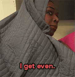 a woman is wrapped in a grey blanket and says `` i get even '' .
