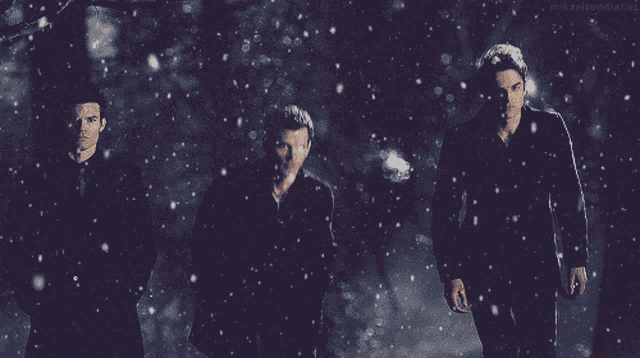 three men are standing in a snowy forest and the words mykaleidoscope are visible