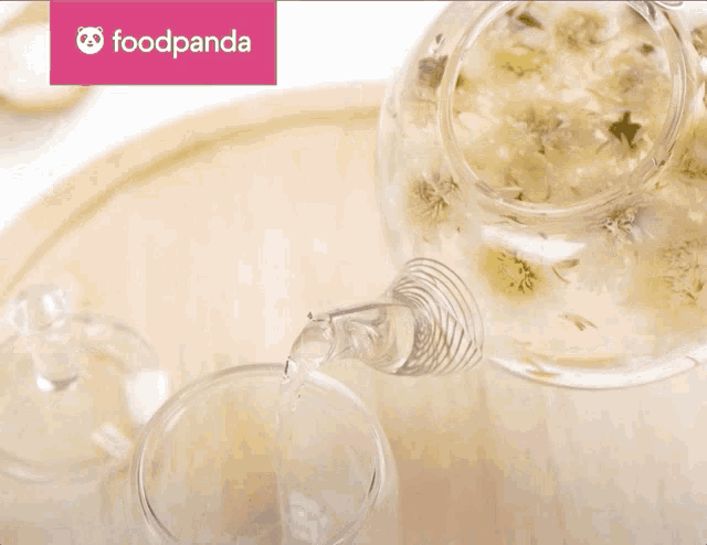 a glass of water is being poured from a teapot with foodpanda written in the corner