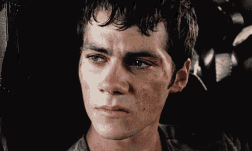 a close up of a young man with a tear running down his face .
