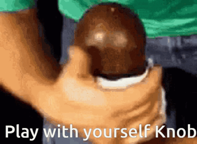 a person is holding a ball in their hand with the words play with yourself knob written below it