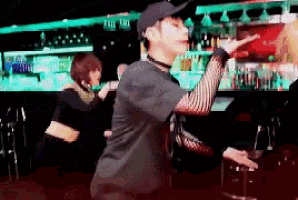 a man in a baseball cap stands in front of a bar