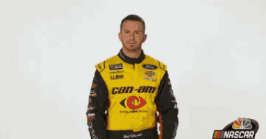 a man in a yellow can-am jacket stands in front of a white background