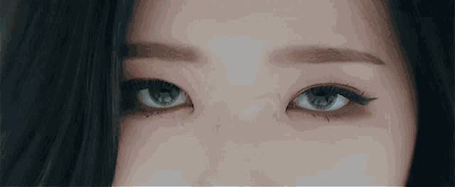 a close up of a woman 's blue eyes with eyeliner