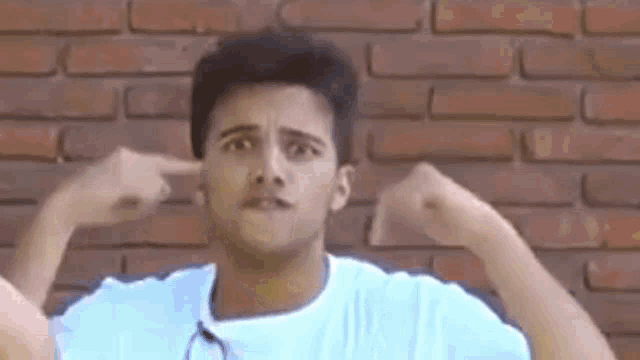 a man in a white shirt is covering his ears with his hands .