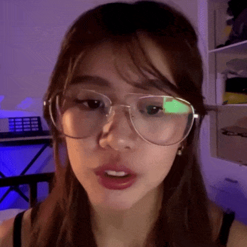 a woman wearing glasses is looking at the camera