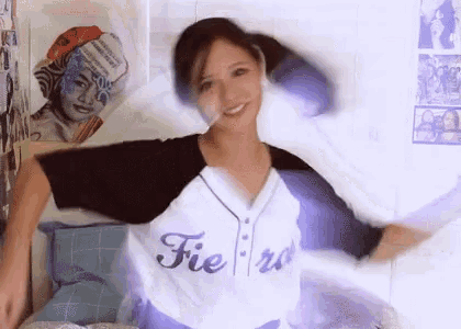 a woman is wearing a baseball jersey with the word fiero on it and dancing .