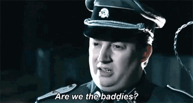 a man in a military uniform is talking to another man in a dark room .