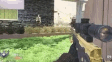 a person is holding a sniper rifle in front of a house .
