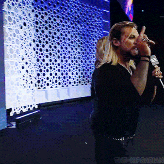 a man singing into a microphone with a nbc logo on it