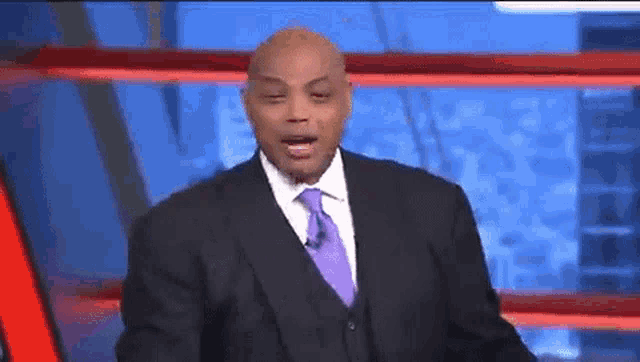 a man in a suit and tie is talking on a television show