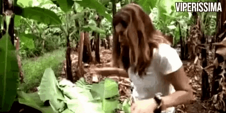 a woman in a white shirt is standing in a jungle with the words viperissima written above her