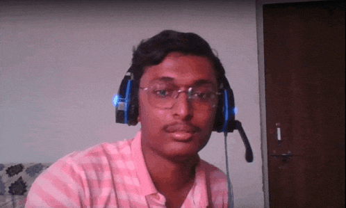 a man wearing headphones and glasses is looking at the camera