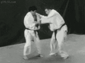 a black and white photo of two men fighting judo .