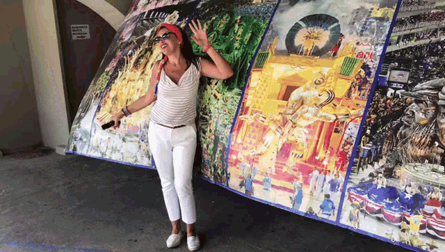 a woman stands in front of a large painting that says ' avenida ' on it