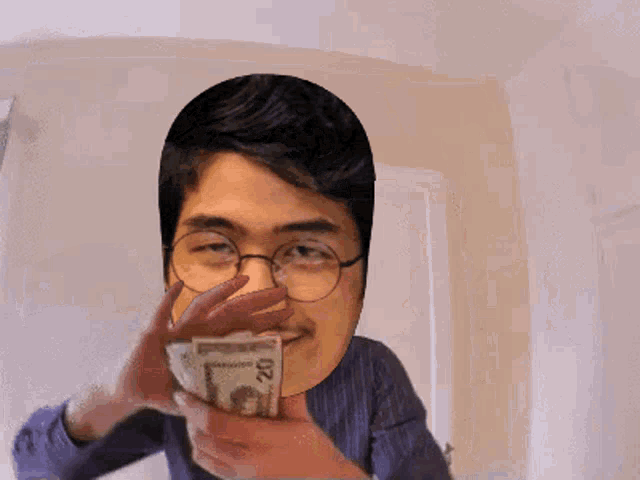 a man with glasses is holding a stack of 20 dollar bills