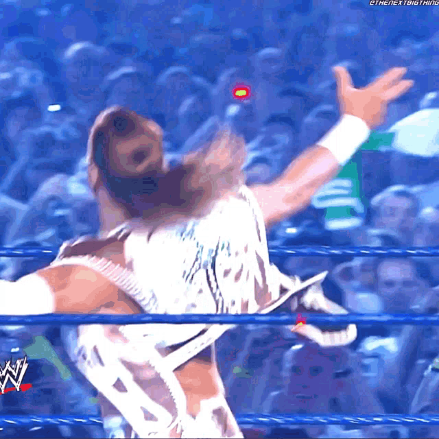 a man in a wrestling ring with a w logo on the bottom