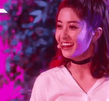 a close up of a woman wearing a choker and smiling