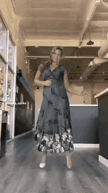 a woman in a blue dress is dancing in a hallway .